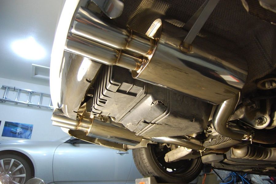 New stainless muffler installed under a car